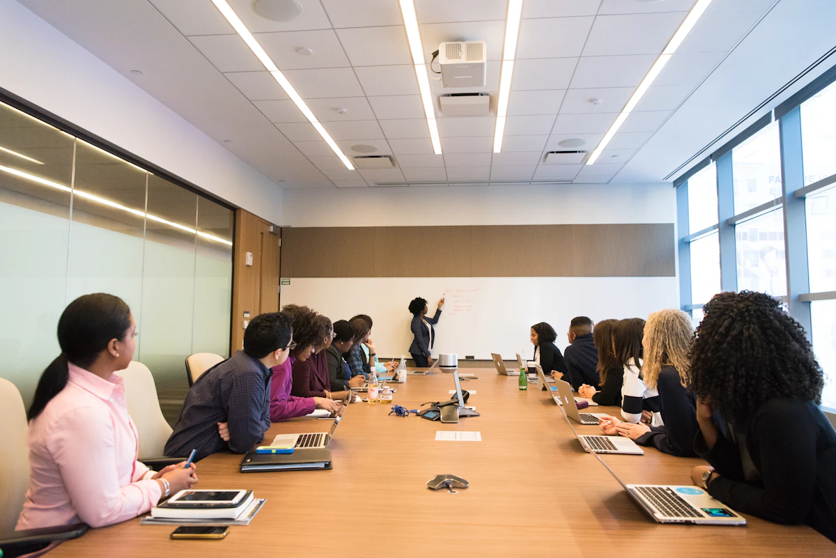 Grupo de profissionais compartilhando conhecimento em uma mesa de reunião.